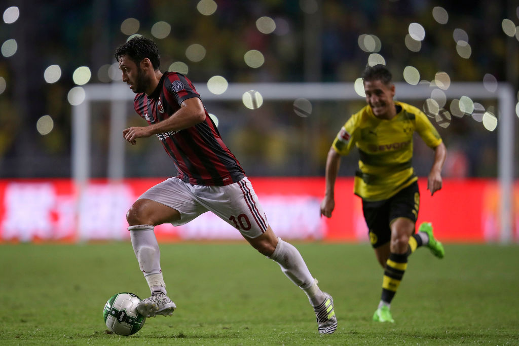 AC Milan midfielder Hakan Calhanoglu dribbles past a Dortmund player. (Getty Images)