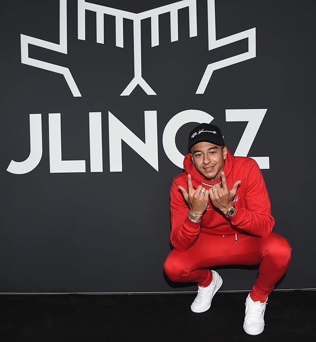 Jesse Lingard in front of the logo of his brand. (Credit: Pinterest) 