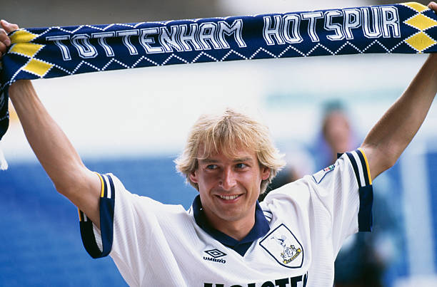 German footballer Jürgen Klinsmann holds up a Tottenham Hotspur scarf after signing with the club, 4th August 1994. 