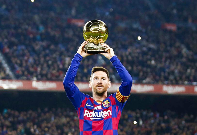 Lionel Messi showing his Ballon d'Or title to the Camp Nou. (Credit: AP/JOAN MONFORT)