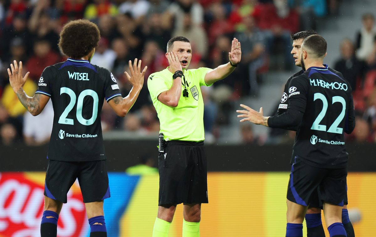 Referee Michael Oliver interacts with Mario Hermoso of Atletico de Madrid during the UEFA Champions League group B match between Bayer 04 Leverkusen and Atletico Madrid.