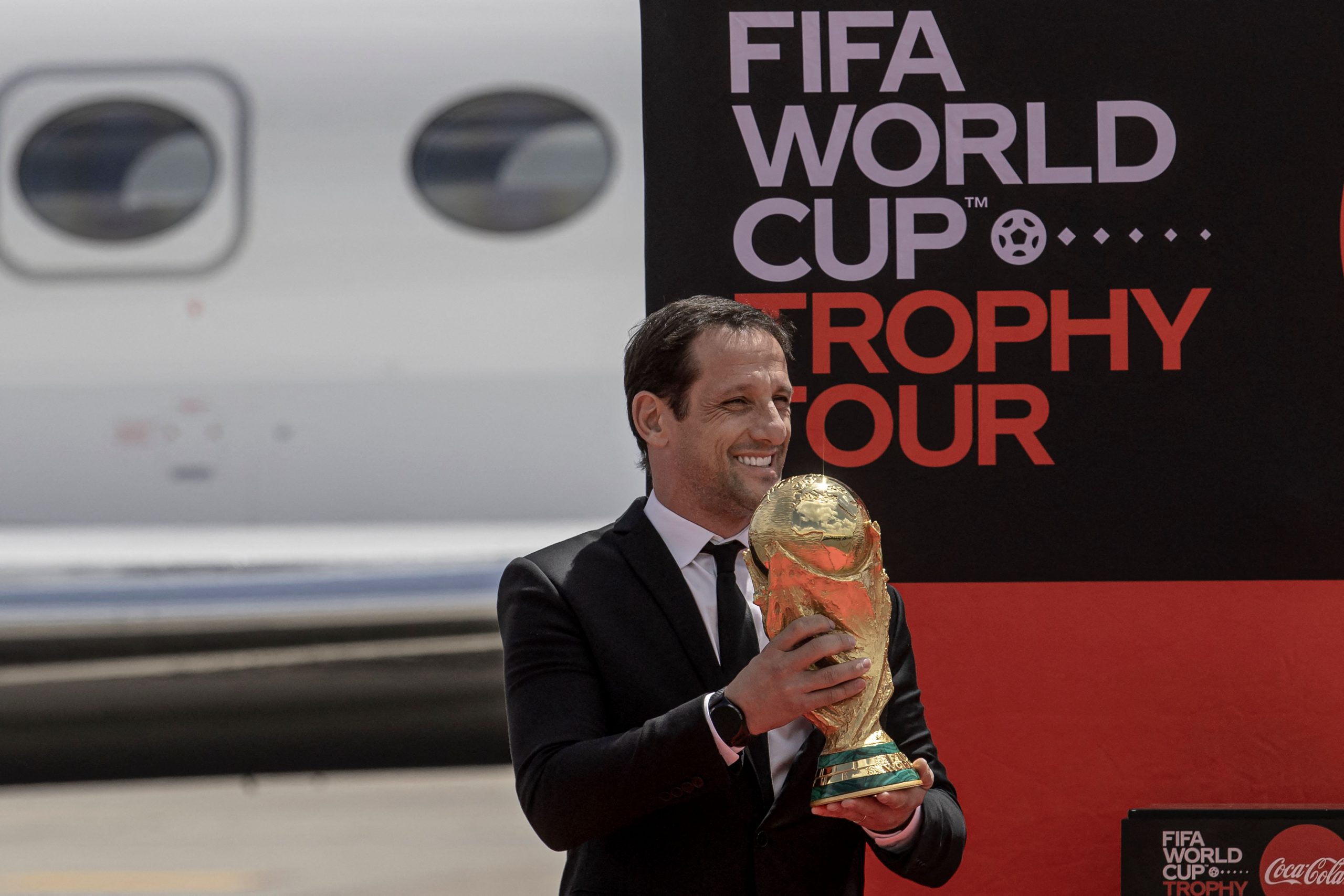 Brazilian football coach, Juliano Haus Belletti who is also a former Brazil national team player disembarks from an aircraft carrying the FIFA World Cup Trophy. (Photo by TONY KARUMBA/AFP via Getty Images)