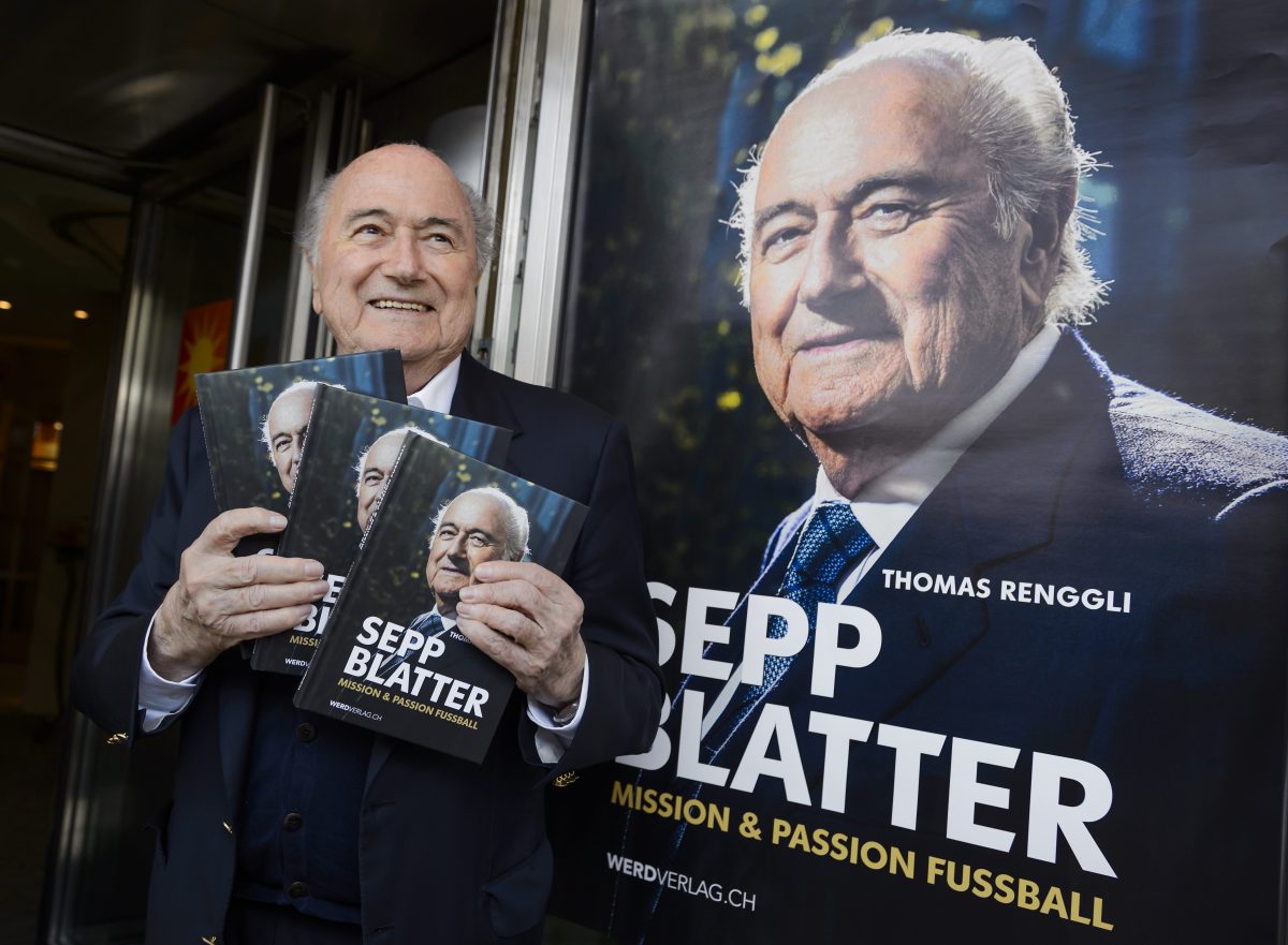 FIFA's ex-president Sepp Blatter with a copy of his biography 'Sepp Blatter: Mission & Passion Fussball'  written by Thomas Renggli.     (Photo credit should read FABRICE COFFRINI/AFP via Getty Images)