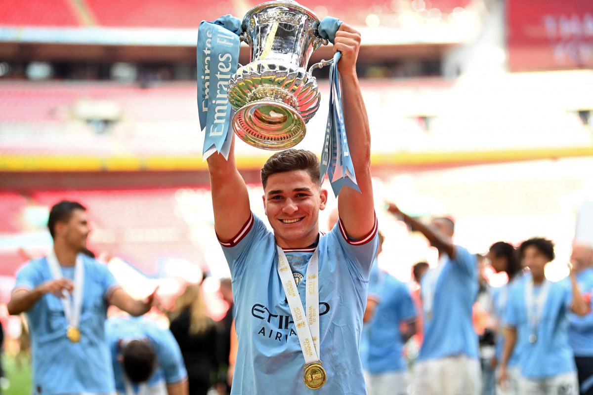Manchester City's Argentinian striker Julian Alvarez celebrates with the FA CUP trophy on the pitch. (Photo by GLYN KIRK/AFP via Getty Images)