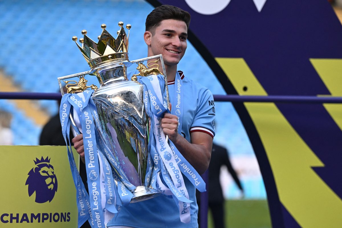 Manchester City's Argentinian striker Julian Alvarez poses with the Premier League trophy. (Photo by OLI SCARFF/AFP via Getty Images)